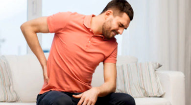 causes of lower back pain and sciatica ( image - a man holding his back)